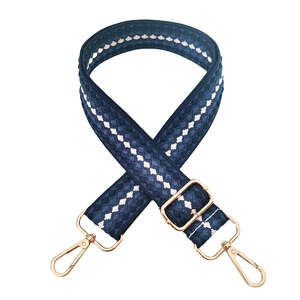 Close-up of thick 3.8cm navy blue diamond pattern strap with gold metal lobster clasps