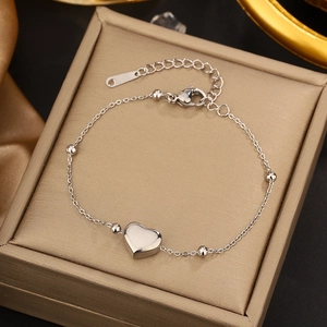 Detailed view of polished heart pendant bracelet with beads on silk jewelry box