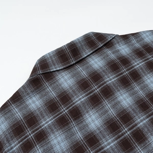 Detail shot of the soft flannel fabric texture and collar stitching on plaid shirt
