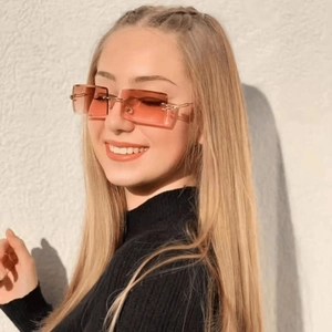 Side view of woman wearing rimless rectangle sunglasses with orange gradient lenses