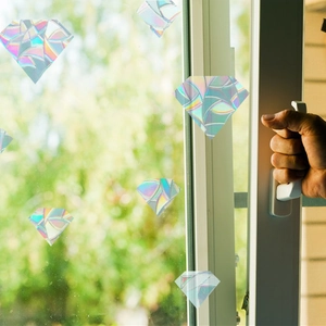 Close-up of diamond shaped holographic window stickers with rainbow prism effect