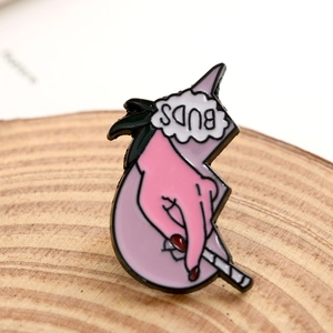 Pink hand holding a cigarette enamel pin with BUDS cloud on round wood piece