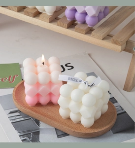 Close-up of pastel bubble cube scented candles on a wooden tray for home decor