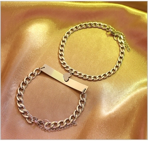Detail of silver titanium steel couple bracelets with heart charm and rectangular plate