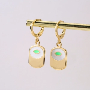 Detail of 18K gold plated earrings with white enamel and green oval eye pattern