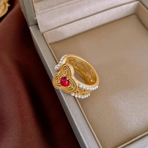 Detail of vintage gold butterfly ring with ruby gemstone and intricate filigree work