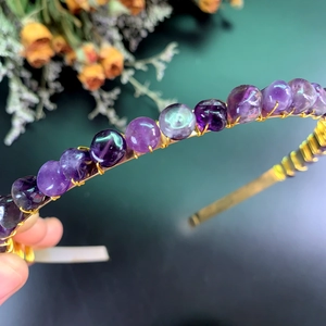 Detailed macro shot of handmade crystal beads wrapped with gold wire on bridal headband