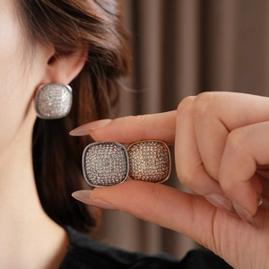 Detail of cushion-cut square stud earrings with pave-set zircon in silver and gold plating