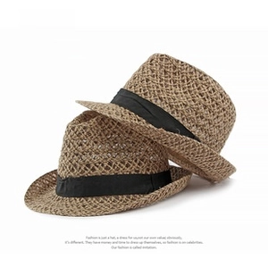 Close-up of lightweight woven straw texture and black decorative ribbon on fedora hats