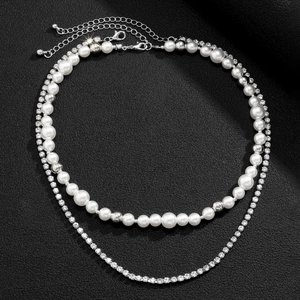 Detail of double-layer necklace featuring white pearls and sparkling rhinestone chain