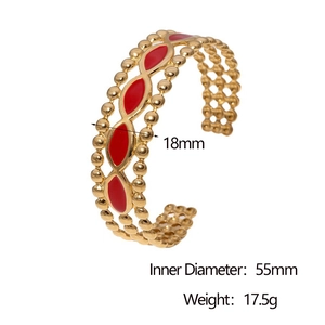 Vue détaillée d'un large bracelet doré avec motifs de vagues en émail rouge et dimensions