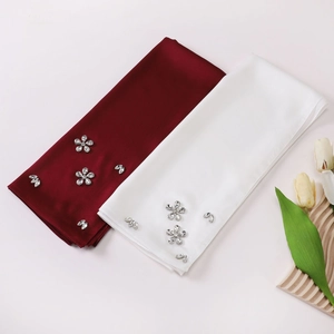Close-up of wine red and white chiffon hijabs with elegant floral rhinestone detailing