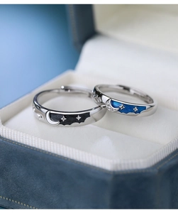 Detail of S925 silver star and moon couple rings in a blue jewelry gift box
