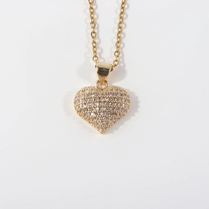 Close-up of gold plated heart pendant necklace with shimmering clear zircon pavé setting