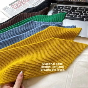 Detail of ribbed knit shawl scarf with unique diagonal edge design in multiple colors
