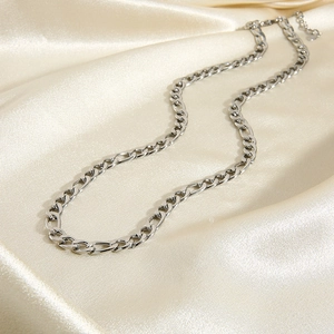 Classic silver stainless steel Cuban link necklace on elegant beige silk background