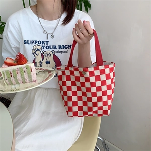 Detail of red and white checkered canvas tote bag with snap button and webbing handles