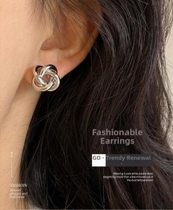Detail of silver twisted knot stud earring worn on model for a minimalist look