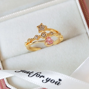 Macro shot of gold-plated ring with pink heart zircon and star details on velvet
