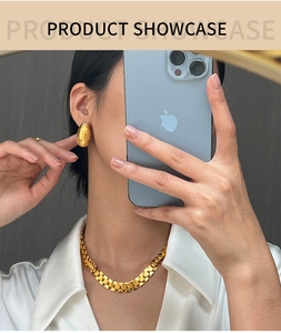 Golden geometric chain necklace and oval textured C-hoop earrings worn by model