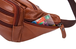 Detail of premium brown lychee grain leather waist bag with multiple zipper compartments
