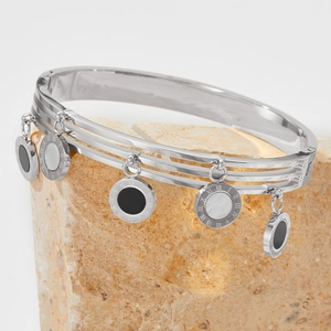 Silver stainless steel bracelet with Roman numeral charms on a natural beige stone
