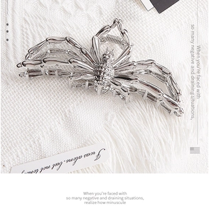 Detailed close-up of a silver spider hair claw clip with a polished metallic finish