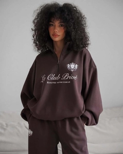 Détail de l'imprimé logo blanc sur le sweat-shirt en molleton marron chocolat avec demi-zip