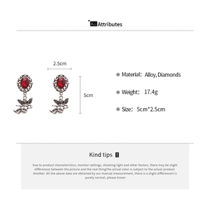 Detailed specs of vintage angel earrings with red oval gemstone and 5cm drop length