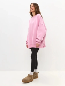 Detailed full body shot of pink oversized crewneck sweatshirt with stylish platform boots
