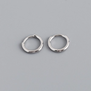 Detailed close-up of polished S925 sterling silver huggie earrings with a mirror finish