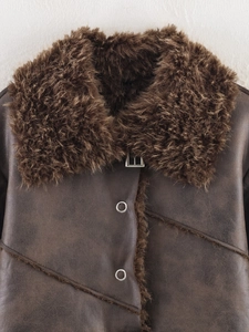 Detailed close-up of a brown shearling jacket featuring thick faux fur lining and buckle
