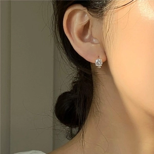 Classic 925 sterling silver four-claw zircon earring worn by a model on the earlobe