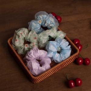 Set mit 5 floralen Organza-Haargummis in Pastellfarben in einem Weidenkorb präsentiert