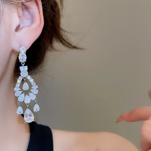 Detail of silver drop earrings with pear-cut cubic zirconia worn by a model