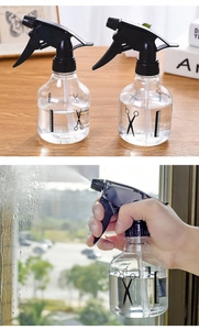 Detail of hand-held spray bottle showing fine mist output against a window pane