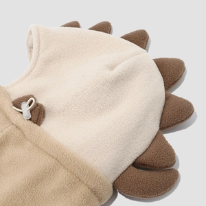 Detail of soft beige fleece hood with brown dinosaur scales and adjustable drawstring