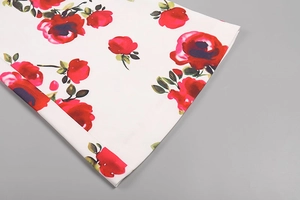 Gros plan sur l'imprimé floral de roses rouges sur un tissu blanc de haute qualité
