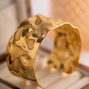 Wide 18K gold stainless steel cuff bracelet with hammered texture in a jewelry box