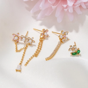 Golden flower earring set with pearls and zircons on white silk background
