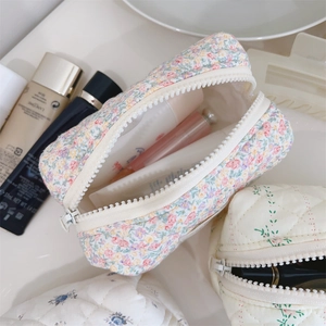 Vue détaillée de la trousse à maquillage fleurie avec fermeture éclair et rangement interne
