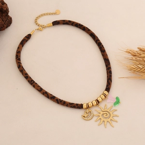 Dettaglio della collana leopardata con ciondoli dorati a forma di sole e luna