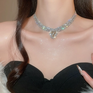 Detail of elegant silver teardrop necklace set with heart shaped crystal and white rhinestones
