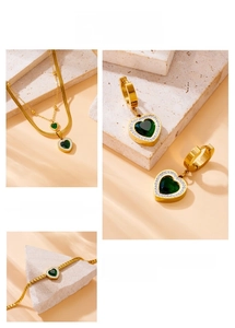 Détail d'un ensemble de bijoux dorés avec pierres vertes en forme de cœur et cristaux