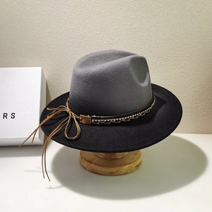 Detail of wool fedora hat with rhinestones, braided band, and brown tassel accents