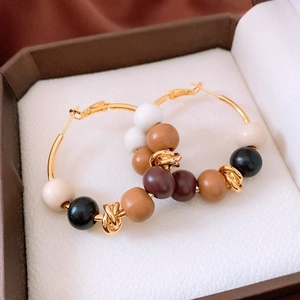 Close-up of retro 18k gold-plated hoop earrings with multicolor tiger eye stone beads