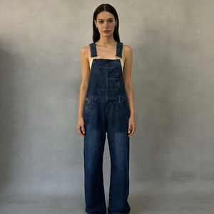 Close-up of dark blue denim overalls with wide legs and functional front pockets