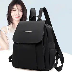 Close-up of minimalist black PU leather backpack with metal bar detail and large capacity