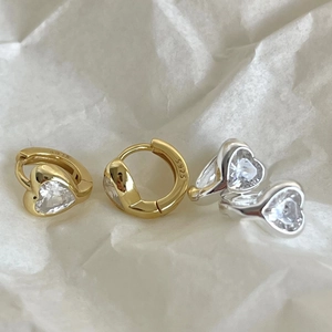 Macro detail of S925 silver stud earrings with heart-shaped cubic zirconia and hallmark