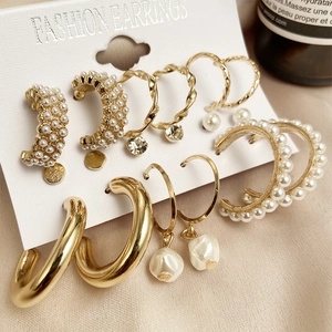 Parure de 9 boucles d'oreilles dorées avec perles et strass sur carte de présentation